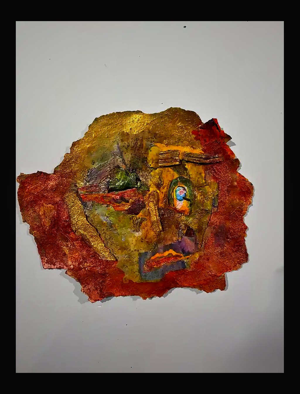 Organic gold and amber form with embedded miniature — a glowing talisman on handmade paper