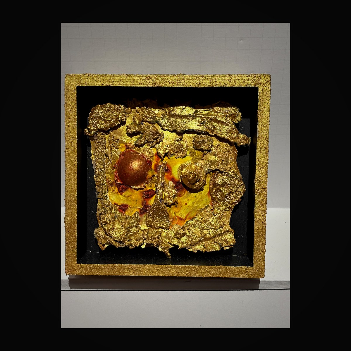 Central gold medallion surrounded by sculpted gold leaf forms in a textured gold frame